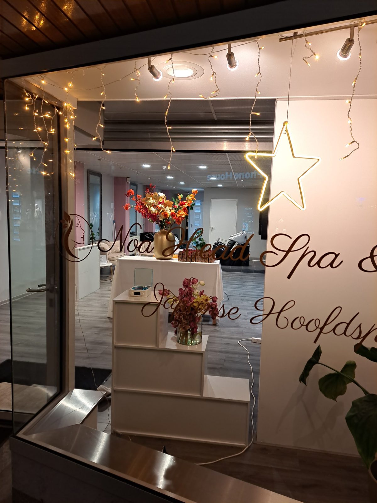 Het etalageraam in de avond, met lichtjes en de letters Japanse Hoofdspa