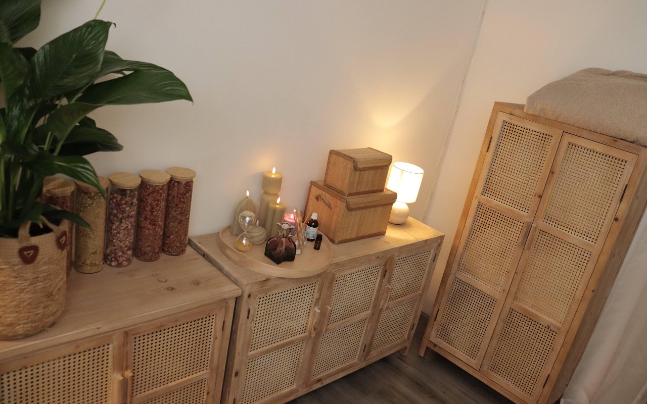 Rotan kast met een kaars, kruidenpotten en een plant